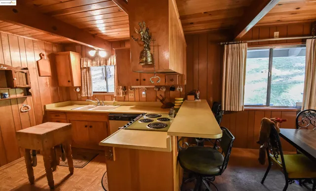 a kitchen with a stove a table and chairs in it