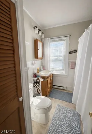 a bathroom with a sink a toilet a window and a mirror