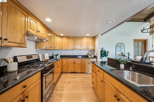 a kitchen with granite countertop a sink and cabinets