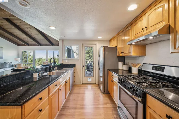 a large kitchen with stainless steel appliances granite countertop a stove and a sink