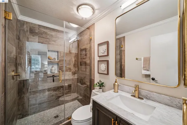 a bathroom with a sink a toilet and shower