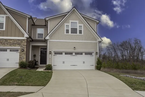 a front view of a house with a yard and garage