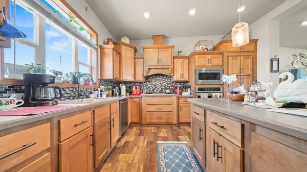 a kitchen with stainless steel appliances kitchen island granite countertop a stove a sink and a refrigerator