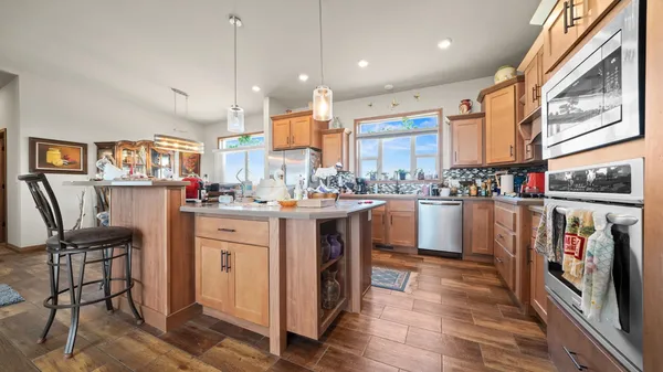 a dining room with furniture a chandelier and wooden floor