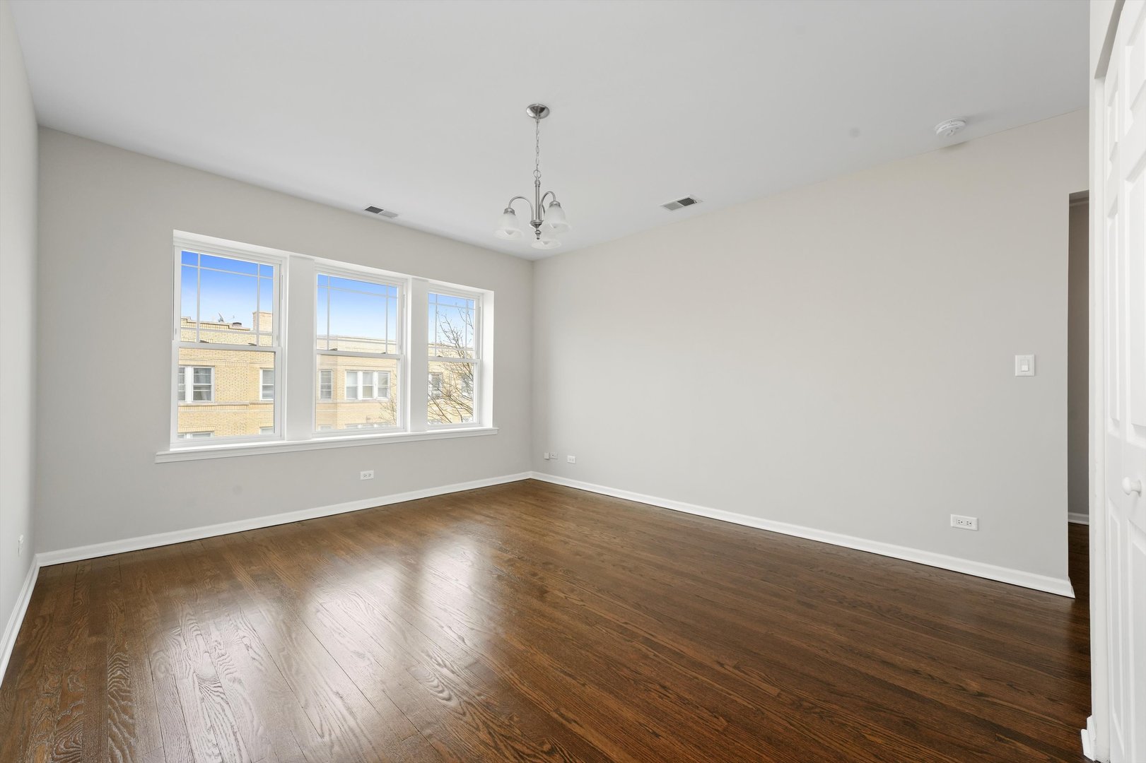800 Dobson Street, Unit 3 Evanston, IL 60202 - Photo 3 of 26 a view of an empty room with wooden floor and a window