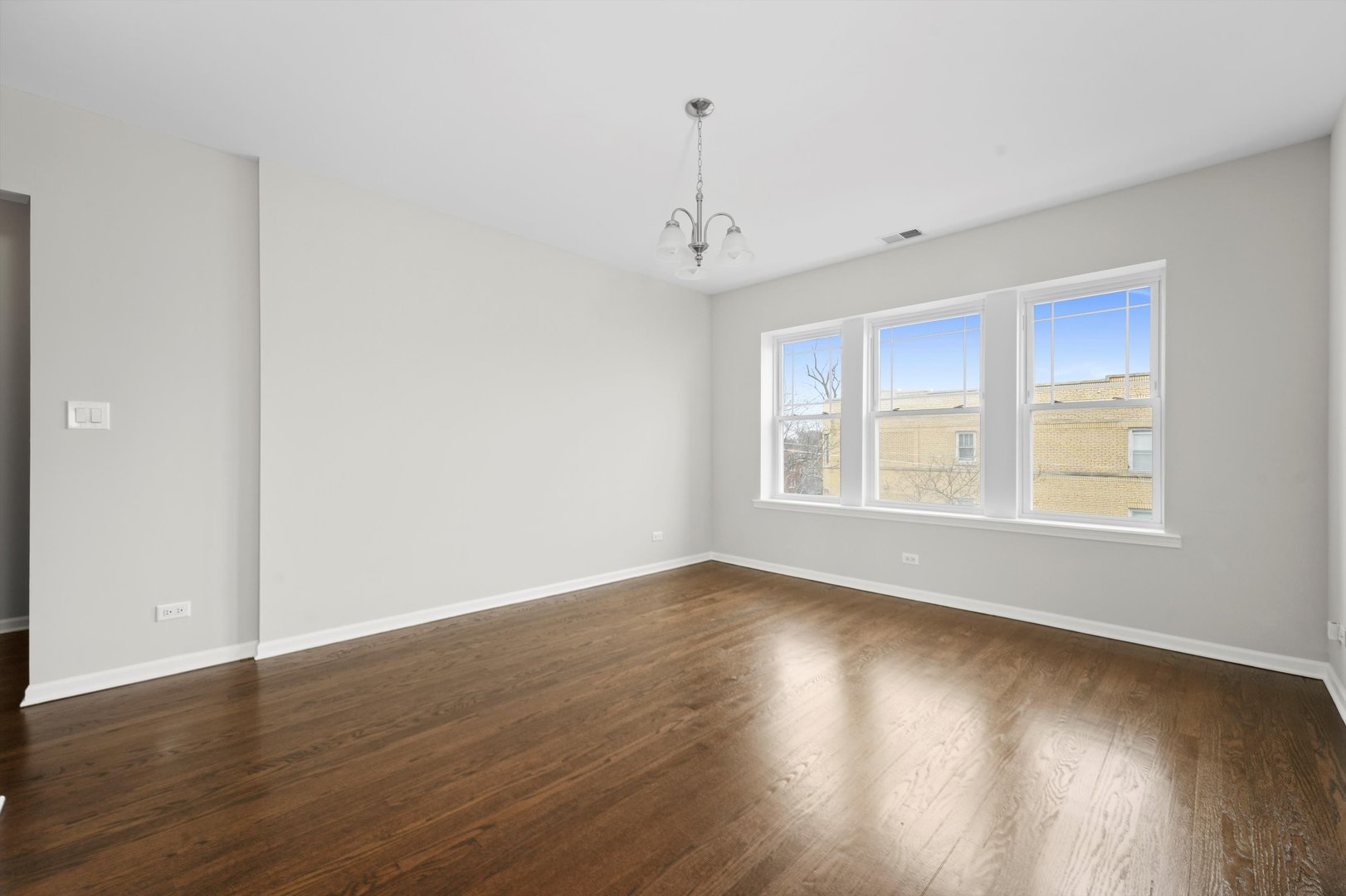 800 Dobson Street, Unit 3 Evanston, IL 60202 - Photo 6 of 26 a view of an empty room with wooden floor and a window