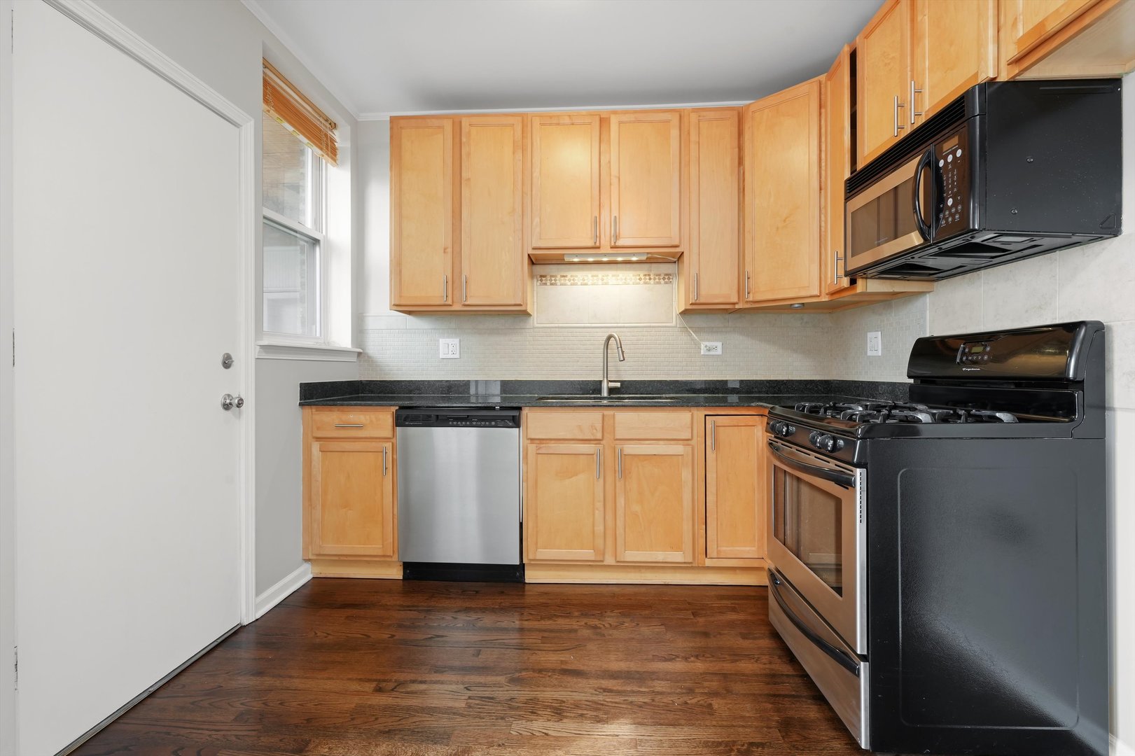 800 Dobson Street, Unit 3 Evanston, IL 60202 - Photo 9 of 26 a kitchen with stainless steel appliances granite countertop a stove a sink and a microwave