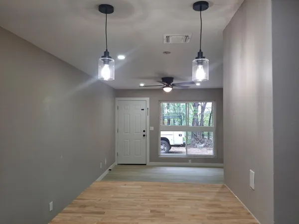 a view of a room with a chandelier fan and windows