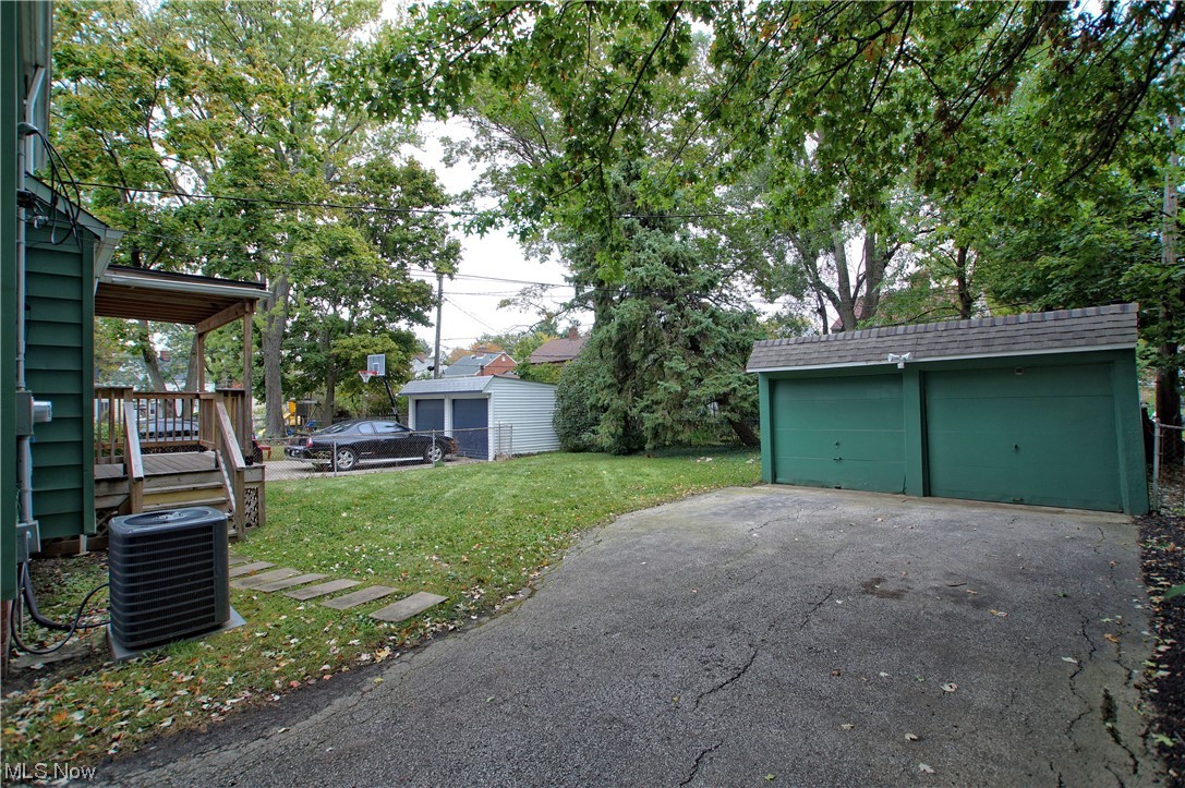 1387 Winston Road Cleveland, OH 44121 - Photo 4 of 29 Garage with a lawn and central AC unit