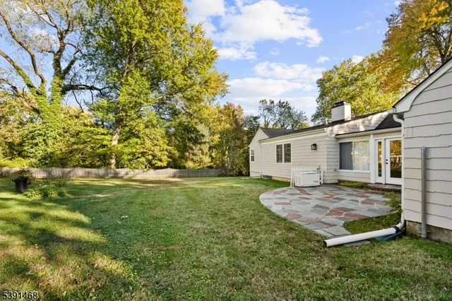a view of backyard with a barn and large trees