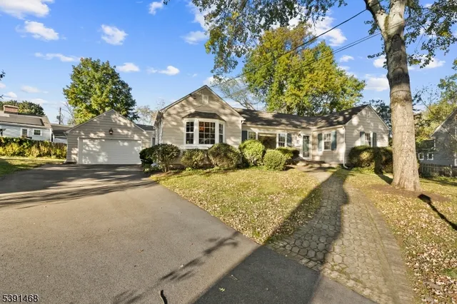 a front view of a house with a yard and trees