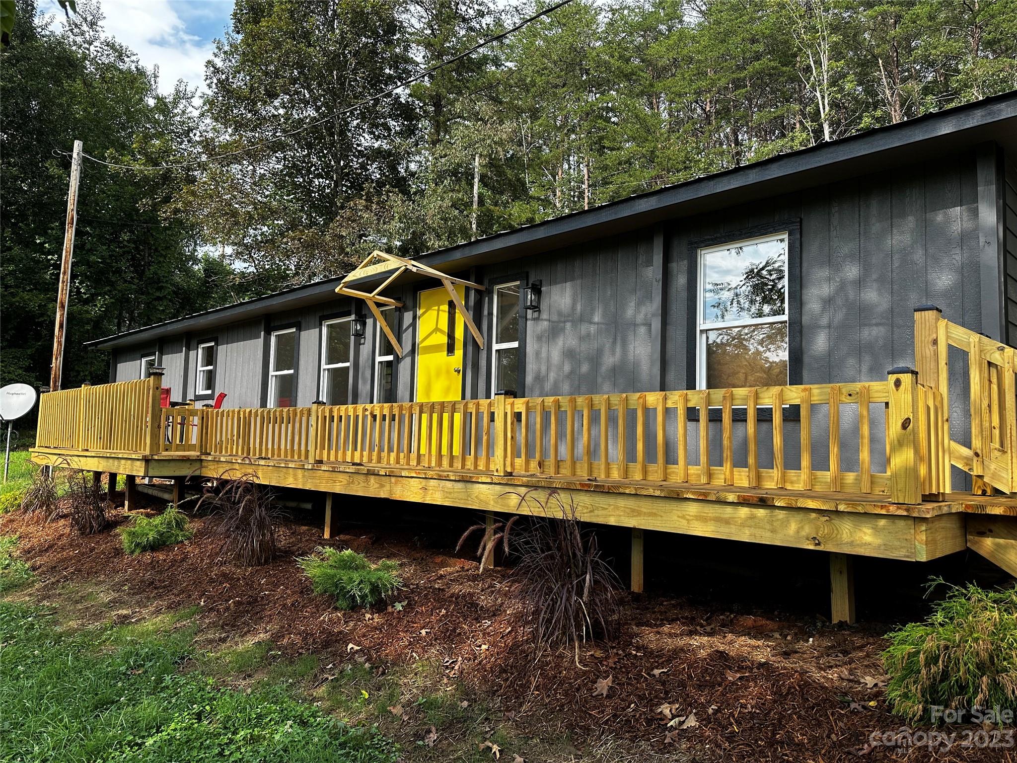 a view of a small house with a yard wooden floor and outdoor seating