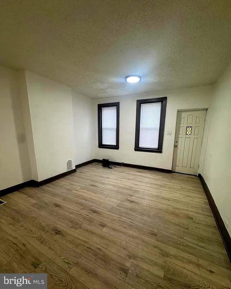 2116 East Cambria Street Philadelphia, PA 19134 - Photo 3 of 9 an empty room with wooden floor and windows