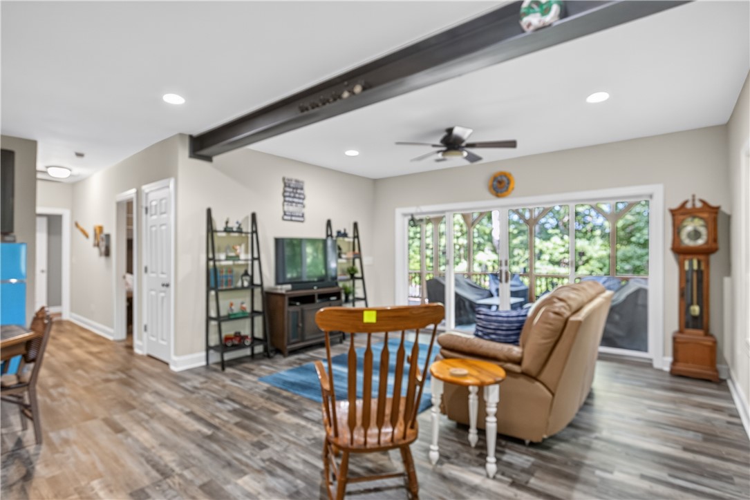 321 High Hampton Road Salem, SC 29676 - Photo 21 of 46 Exposed structural beams and wood-look flooring ground this comfortable living room framing outdoor views.