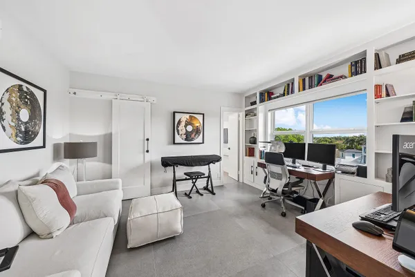 a living room with furniture large window and a table