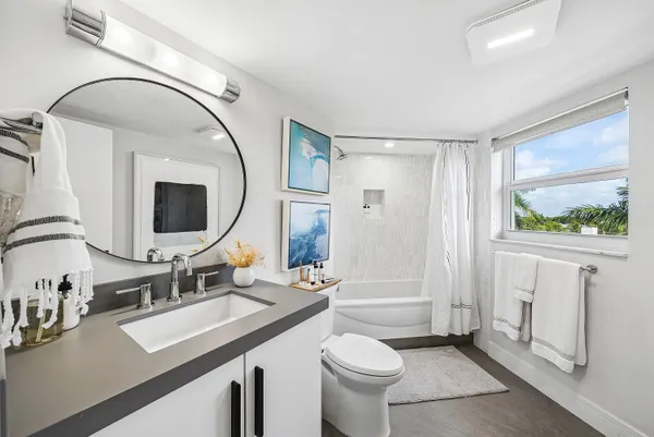 a bathroom with a sink a toilet and a mirror