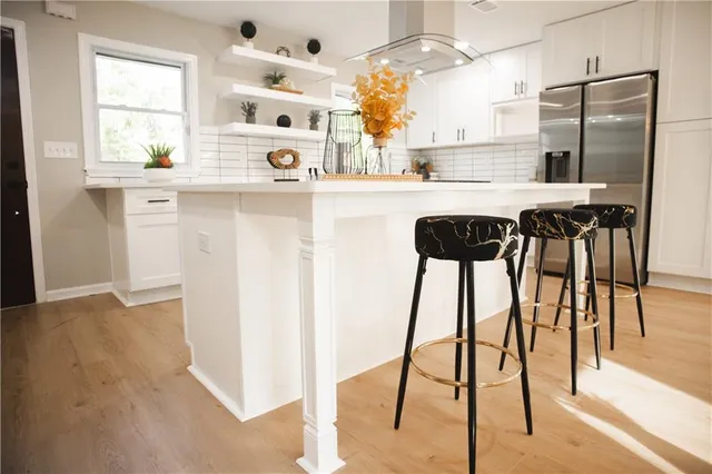 a kitchen with kitchen island a counter top space appliances and a window