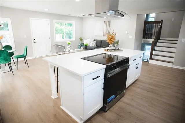 a kitchen with a stove and a wooden floor
