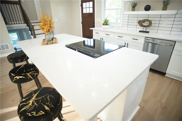 a kitchen with appliances cabinets and chair