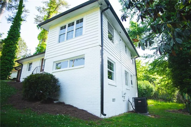 a view of a house with backyard and a tree