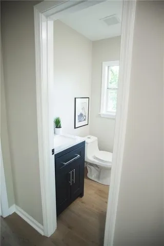 a view of bathroom with a toilet a sink and a mirror