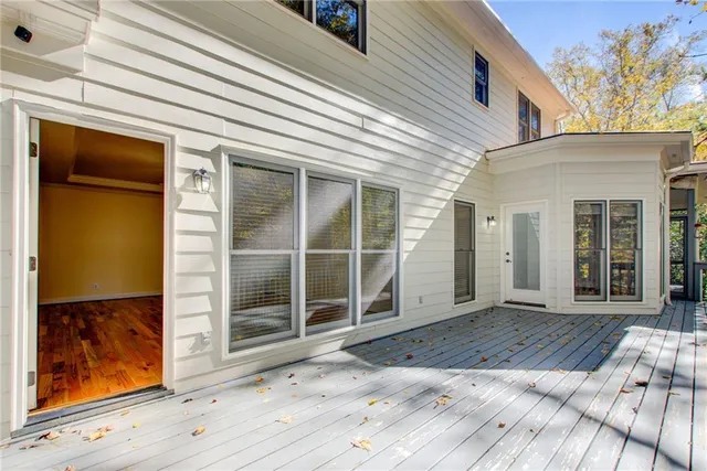 a view of a hallway with wooden floor and a bathroom