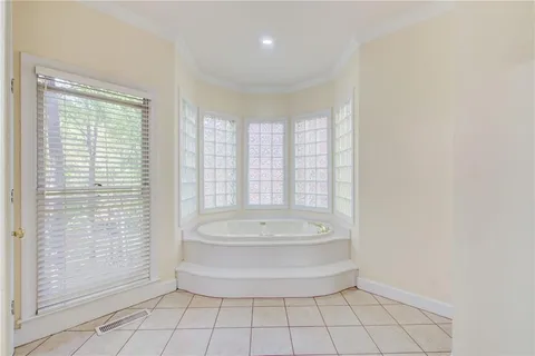 a view of an empty room with wooden floor a ceiling fan and a kitchen view