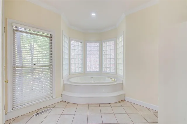a view of an empty room with wooden floor a ceiling fan and a kitchen view