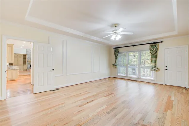 an empty room with windows and ceiling fan