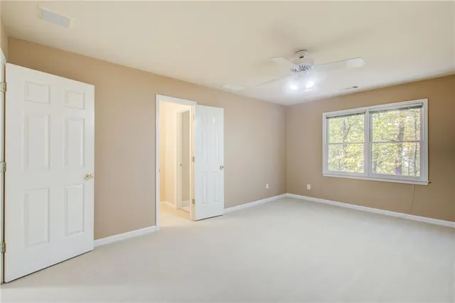 a view of an empty room with a ceiling fan