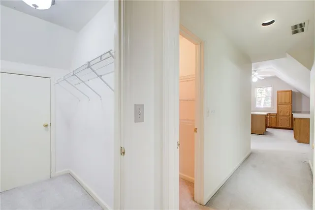 an empty room with wooden floor ceiling fan and windows