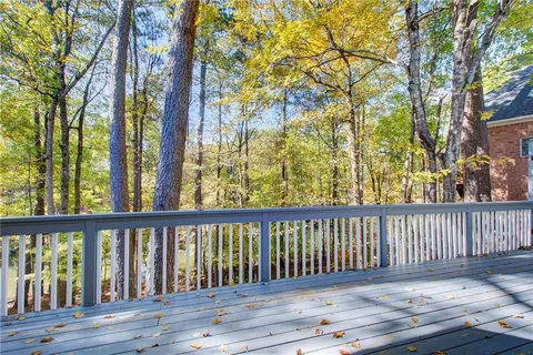 a kitchen with kitchen island a stove a sink a refrigerator and white cabinets with wooden floor