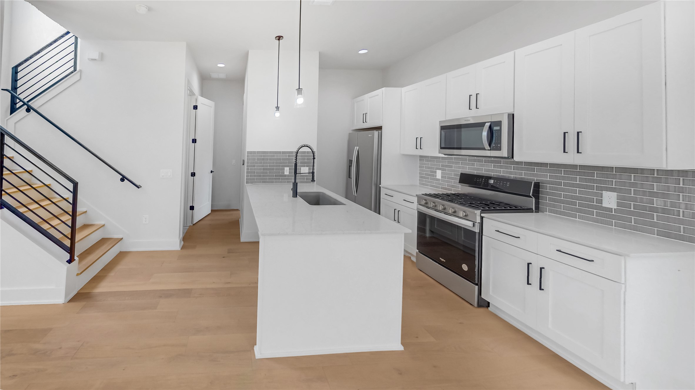 4424 Hank Avenue, Unit 2 Austin, TX 78745 - Photo 4 of 11 A pristine kitchen features sleek stainless steel appliances and an inviting island with pendant lighting.