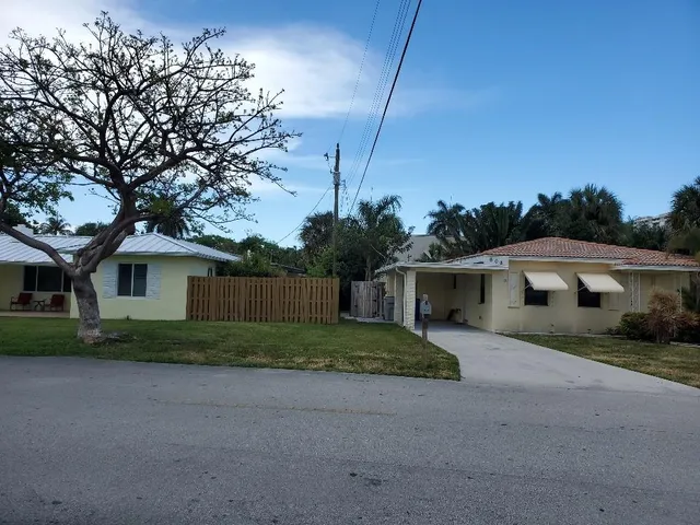 a view of a house with a yard and large trees
