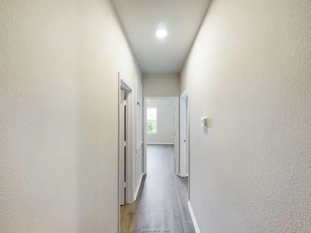 a view of a hallway with wooden floor