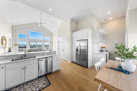 a kitchen with stainless steel appliances a dining table chairs and chandelier
