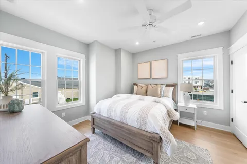 a spacious bedroom with a bed and wooden floor