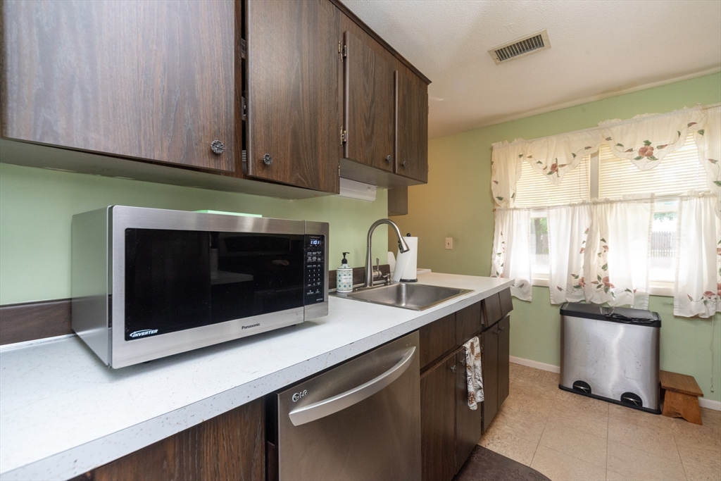 221 Sinclair Road Brockton, MA 02302 - Photo 10 of 26 a kitchen with stainless steel appliances a stove a microwave a sink and cabinets