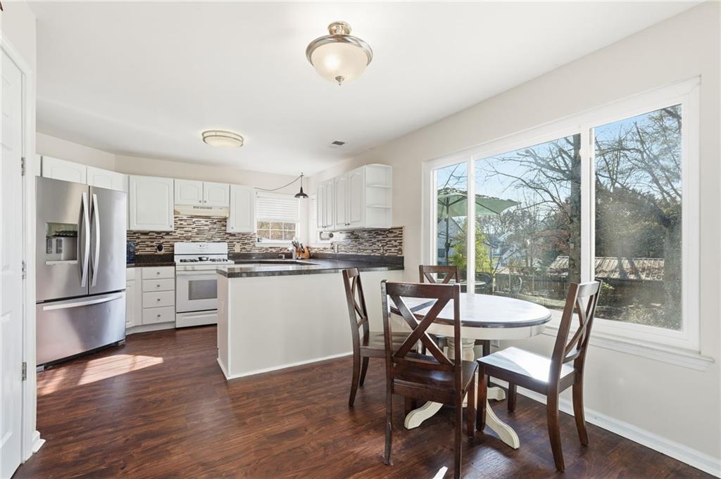7140 Hunters Trace Drive Cumming, GA 30028 - Photo 12 of 35 a kitchen with a table chairs refrigerator and microwave