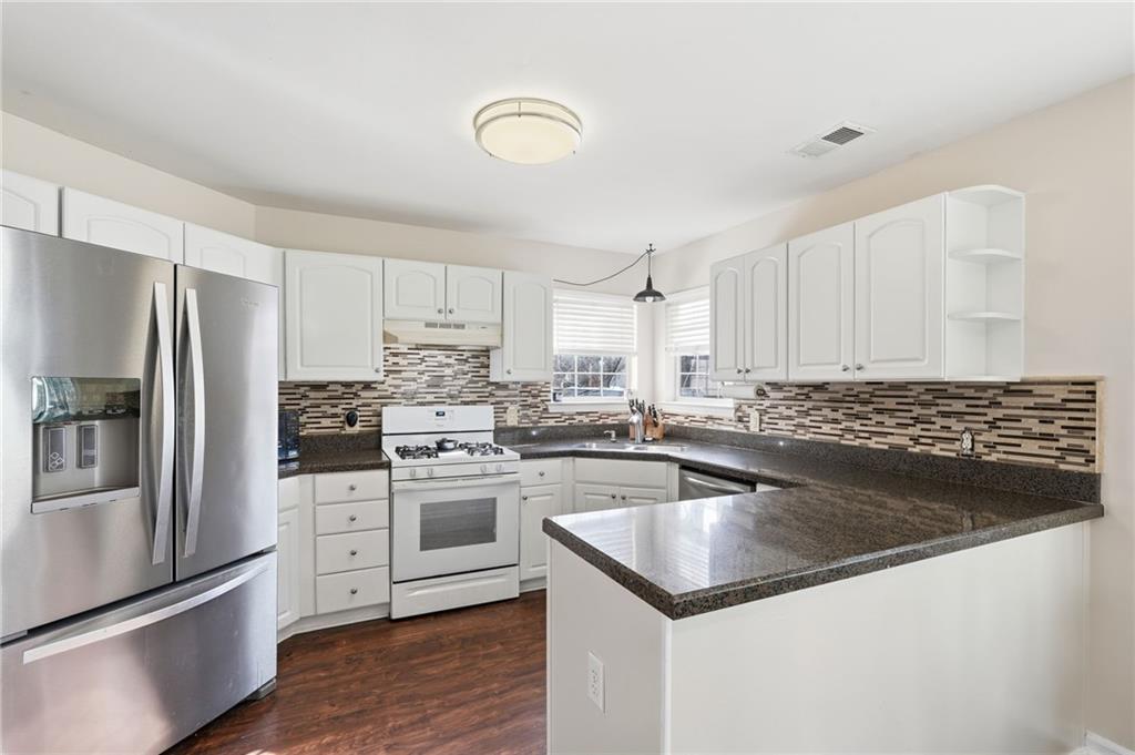 7140 Hunters Trace Drive Cumming, GA 30028 - Photo 13 of 35 a kitchen with a refrigerator sink and cabinets