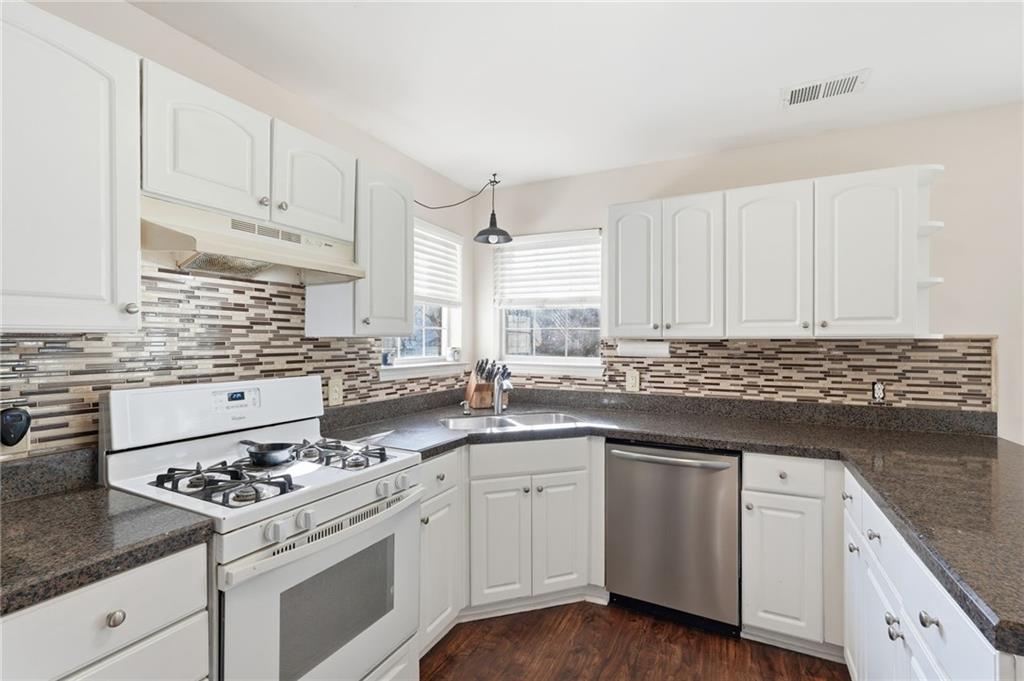 7140 Hunters Trace Drive Cumming, GA 30028 - Photo 14 of 35 a kitchen with white cabinets and appliances