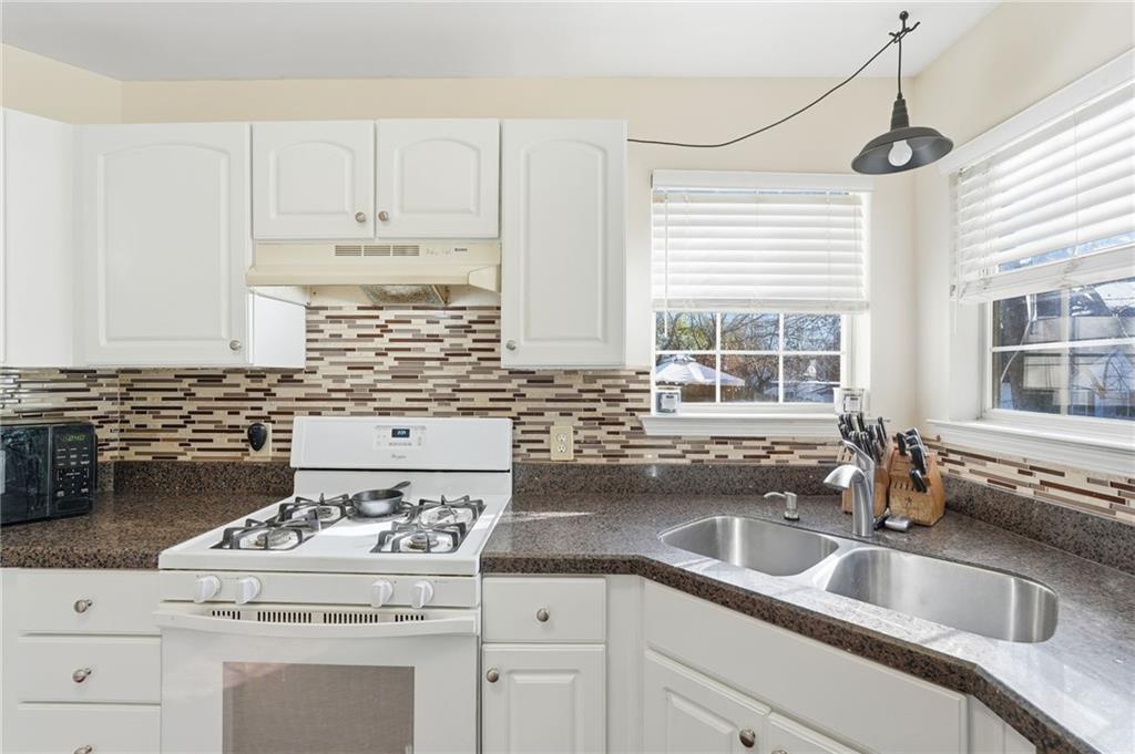 7140 Hunters Trace Drive Cumming, GA 30028 - Photo 15 of 35 a kitchen with granite countertop a sink white cabinets and white stainless steel appliances