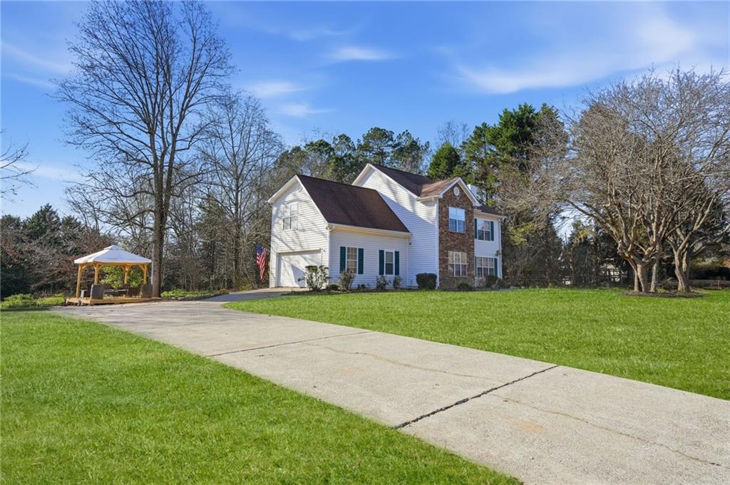 7140 Hunters Trace Drive Cumming, GA 30028 - Photo 3 of 35 a front view of a house with a yard and trees