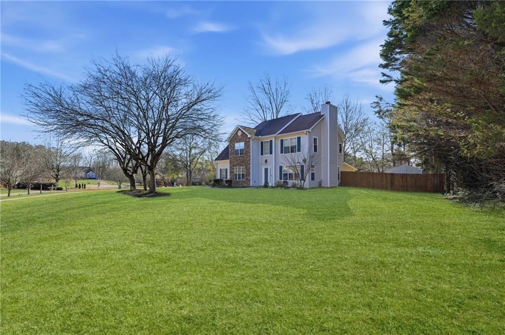 7140 Hunters Trace Drive Cumming, GA 30028 - Photo 4 of 35 a view of a big house with a big yard plants and large trees