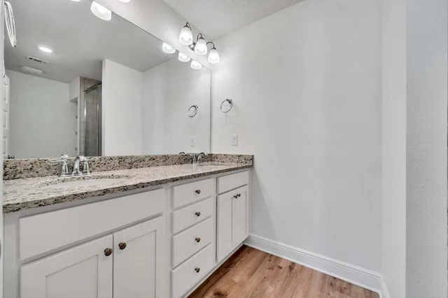 a bathroom with a granite countertop sink and a mirror