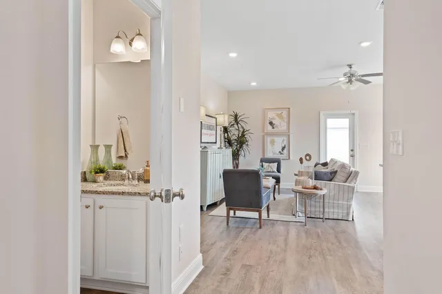 a open kitchen with stainless steel appliances granite countertop a stove top oven a sink dishwasher a dining table and chairs with wooden floor