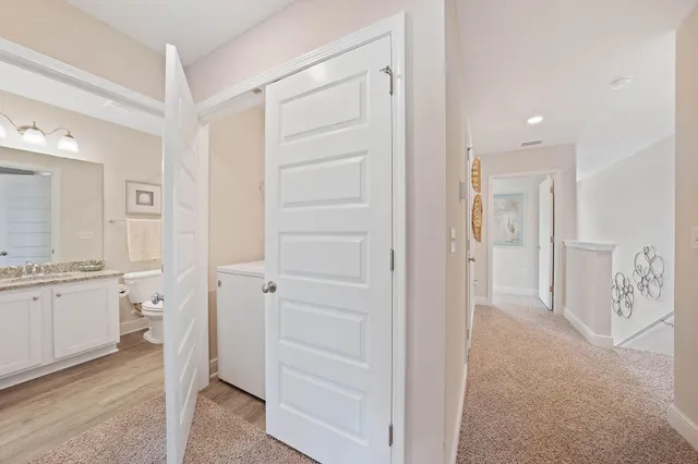 a bathroom with a granite countertop sink a toilet a mirror a bathtub and shower