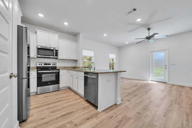a kitchen with granite countertop a stove top oven and cabinets