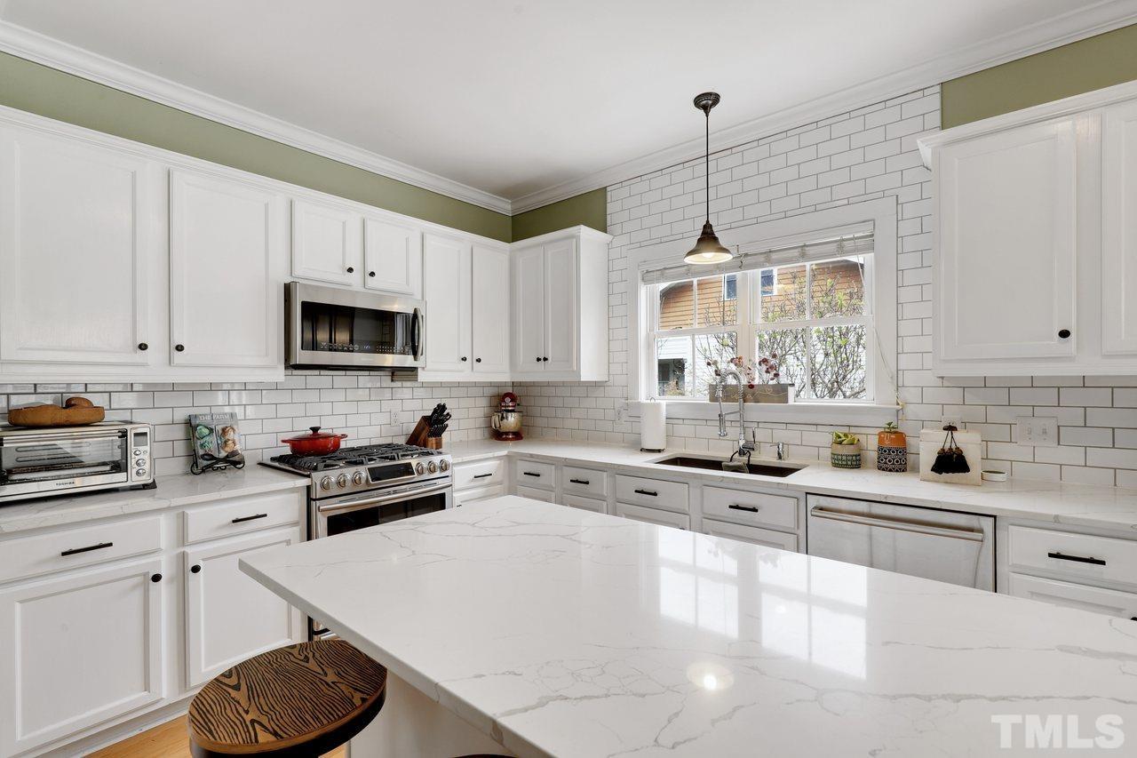121 East Seeman Street Durham, NC 27701 - Photo 12 of 31 a kitchen with stainless steel appliances granite countertop a sink a stove and cabinets