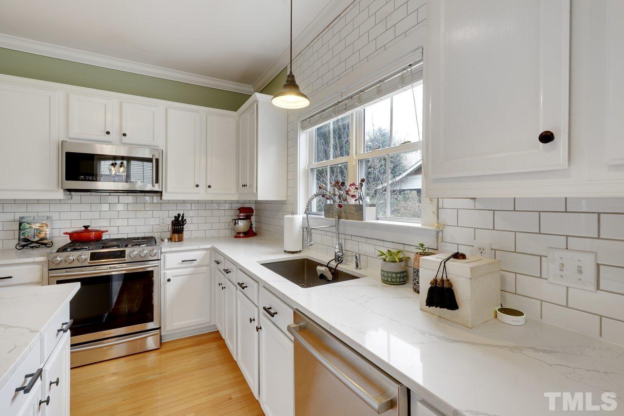 121 East Seeman Street Durham, NC 27701 - Photo 9 of 31 a kitchen with a sink dishwasher a stove and white cabinets with wooden floor